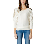 Woman wearing Guess White Viscose Sportswear sweater with batwing sleeves, featuring a subtle logo detail, paired with blue jeans.