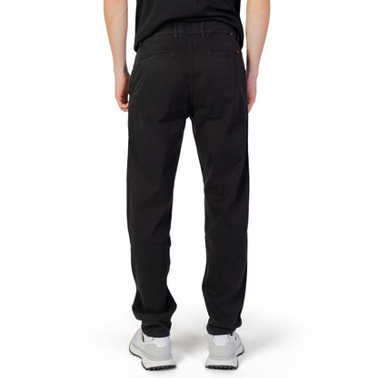 Back view of a man wearing Hugo Boss Black Cotton Chino Pants, showcasing tapered fit and comfortable style with elastane flexibility.