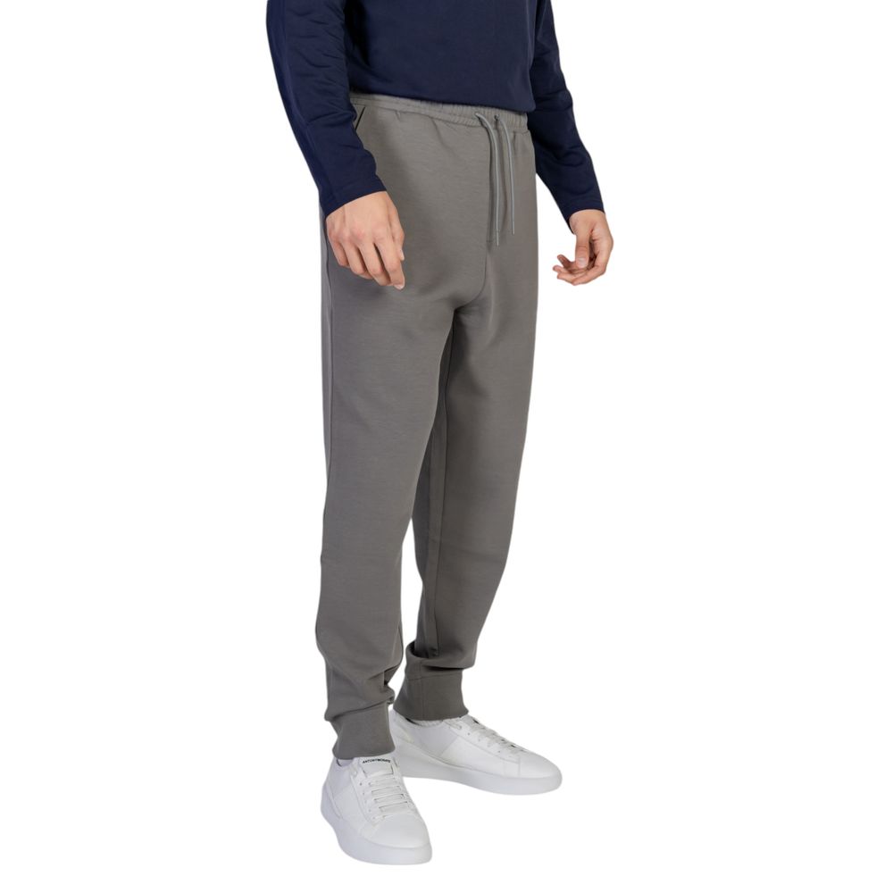 Man wearing Hugo Boss Gray Cotton Joggers Workout Pant with elastic waistband, drawstrings, and ribbed cuffs for flexible fit.