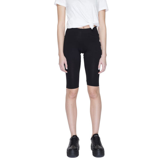 Woman wearing Icon Black Cotton Bermuda Shorts with 'ICON' print, showcasing modern style and comfort, paired with white top and black shoes.
