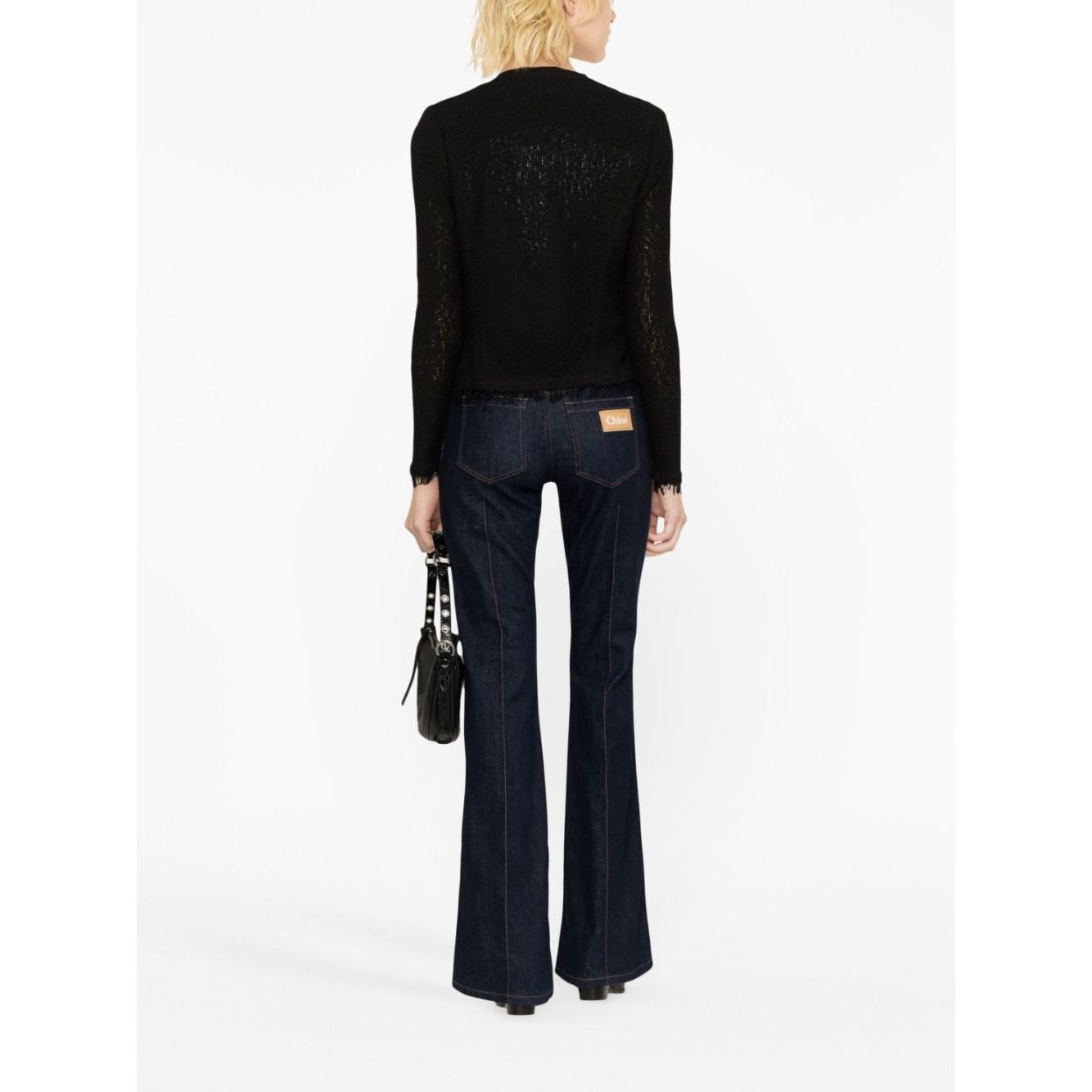Back view of model wearing Iro Jackets Black with fringe detailing and round neck.