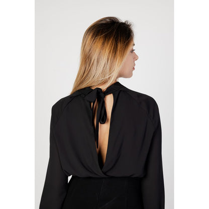 Back view of a woman wearing Sandro Ferrone Black Polyester Blouse with open back and tie detail.