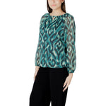 Model wearing Street One Green Polyester Blouse with a patterned design, long sleeves, and round neckline, styled with dark pants.