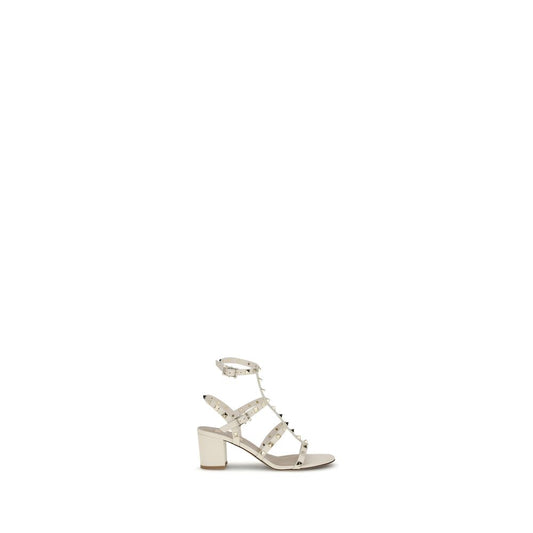 Valentino Garavani Cream Calf Leather Bos Taurus Sandals with Rockstuds, adjustable ankle strap, and chunky heel for elegant style.