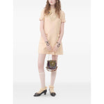 "Valentino Short Crepe Couture Dress in beige with bow detailing, crew neck, rear zip fastening, made of wool and silk, styled with socks and bag"