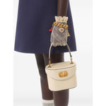 Woman holding a handbag wearing Valentino Short Embroidered Crepe Couture Dress, showcasing navy blue fabric with lace glove accessory.