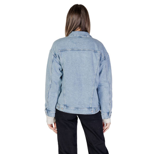 Rear view of woman wearing Vero Moda Light Blue Cotton Jackets & Coat, oversized denim jacket with classic design details.