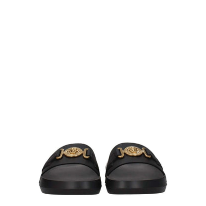 Versace Black Leather Slippers with gold front detail and logo, featuring rubber sole, open toe, and low flat heel. Casual style footwear.